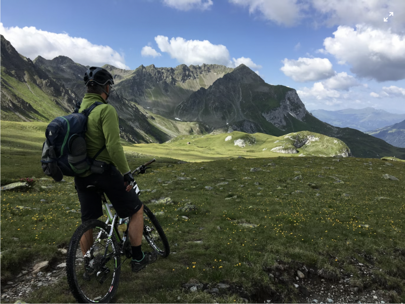   Un homme tenant un vélo avec vue sur les montagnes en Suisse