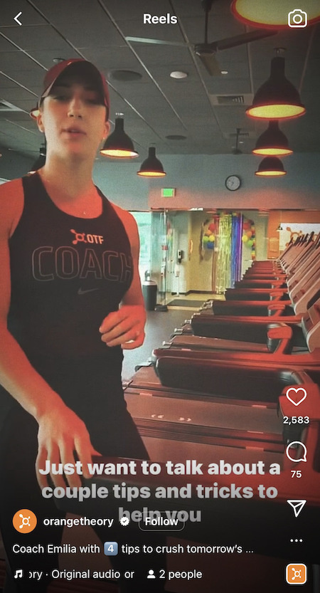   Ένα OrangeTheory Instagram Reel με έναν προπονητή σε ένα από τα γυμναστήρια σε διάδρομο καθώς παρέχουν συμβουλές προπόνησης.