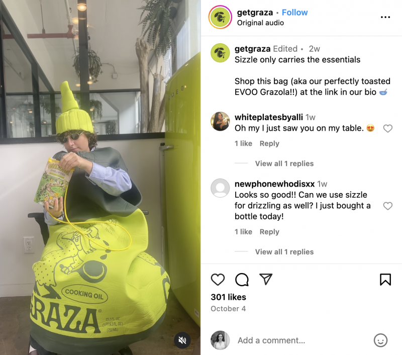   grâce's mascot Sizzle showing off their purse that's really a bag of granola