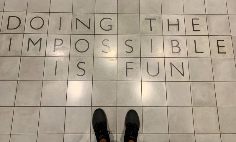 Una imatge de Ryan Barretto's feet standing next to tiles that say "Doing the impossible is fun."